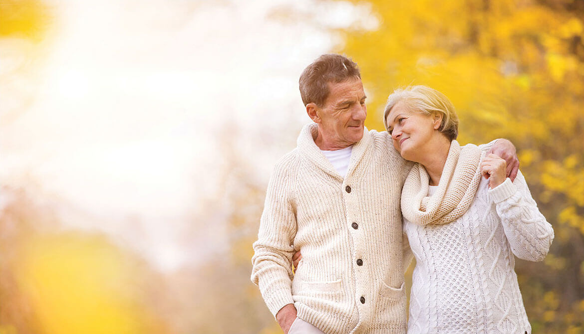 happy retired couple with fall leaves in the background