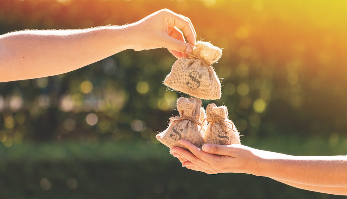 two hands exhanging a bag of money