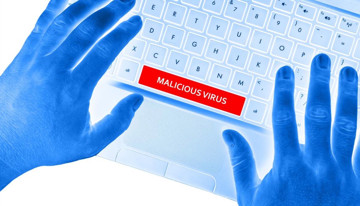 techy looking blue hands on keyboard with a space bar that says malicious virus