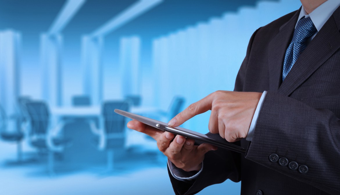 director using a tablet near the board table