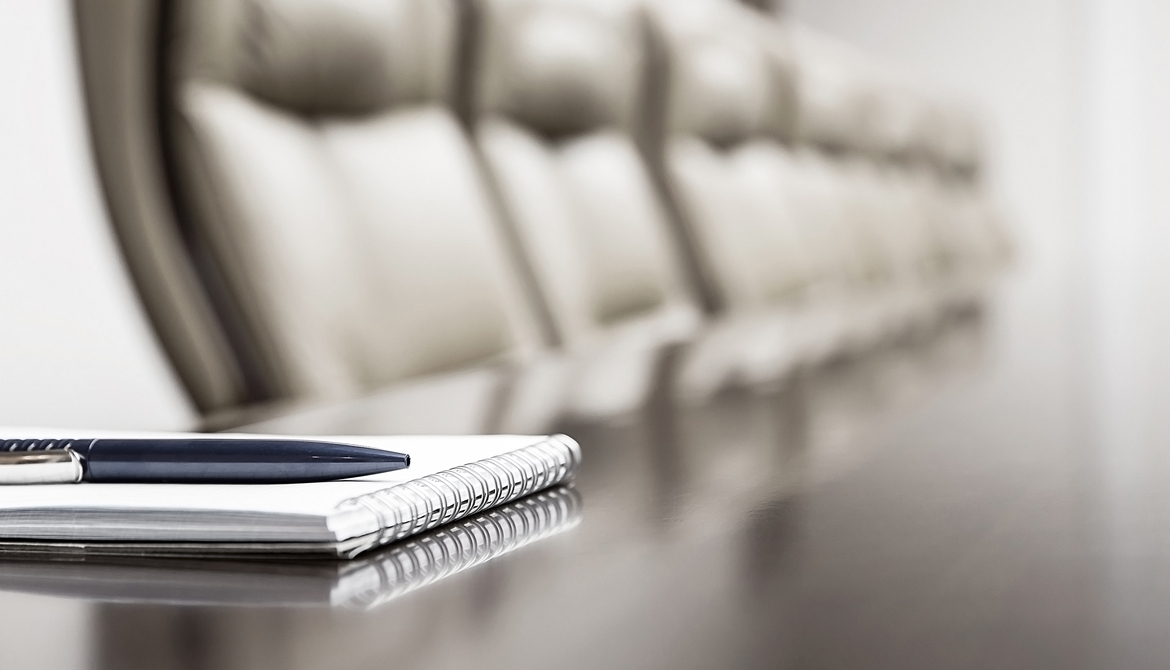 board chairs at a table with a notebook nearby