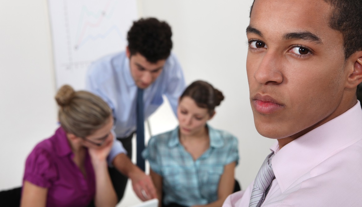 African American business man looking worried with colleagues blurred in the background