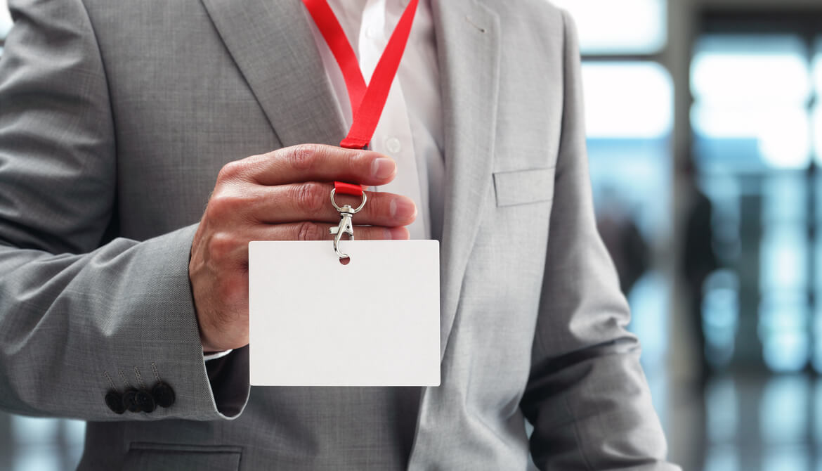 Businessman holding blank ID badge