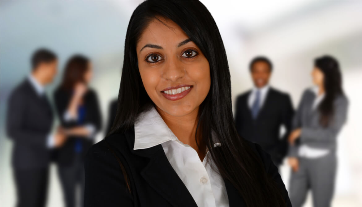 A female CEO stands in front of a group of employees