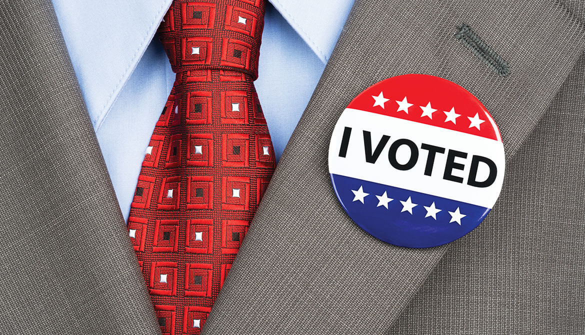 red tie and suit lapel with I Voted button