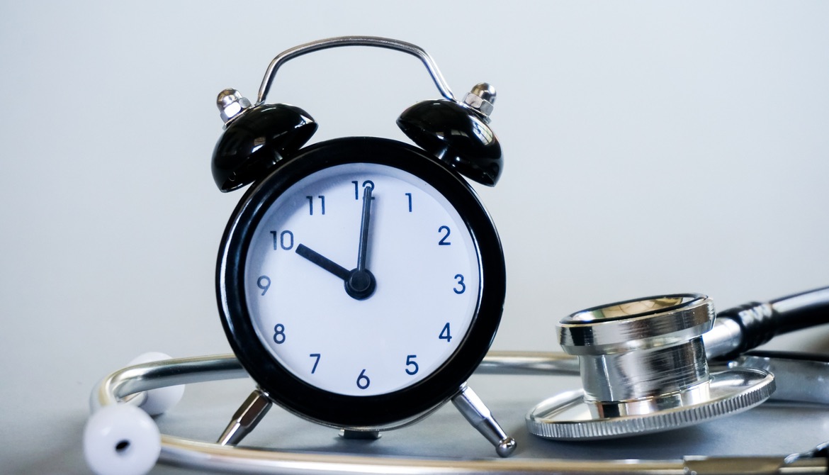 alarm clock sitting next to a stethoscope