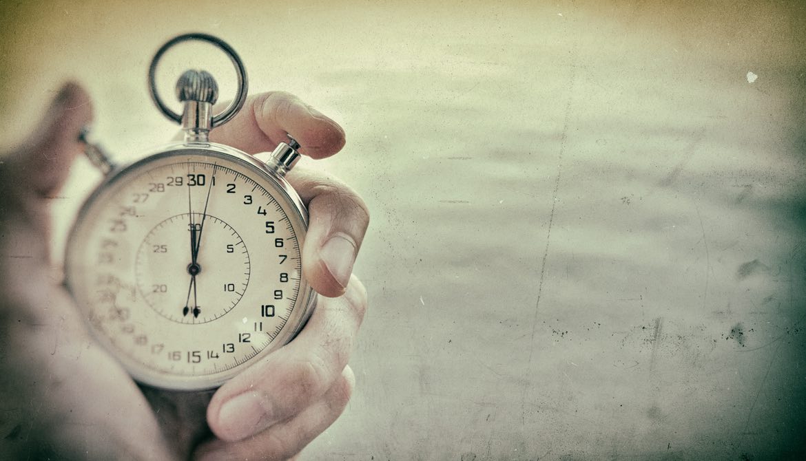 old photo of hand holding chrome stopwatch