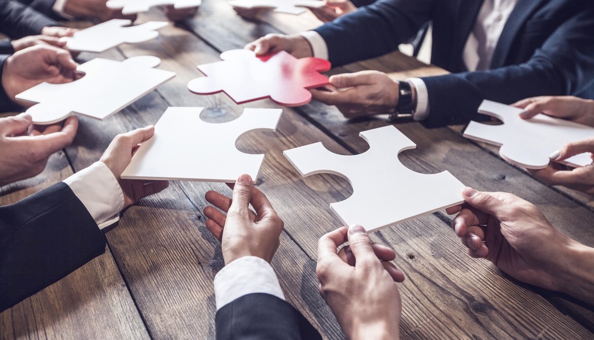 board members holding puzzle pieces with red piece representing the CEO