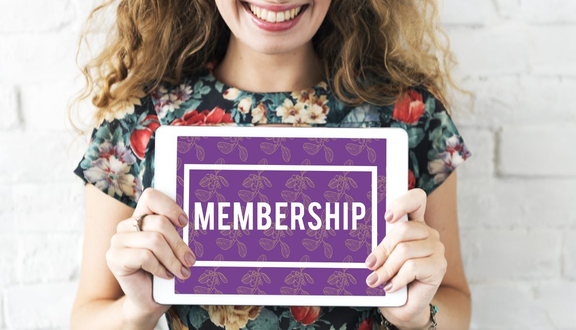 woman holding sign with word membership