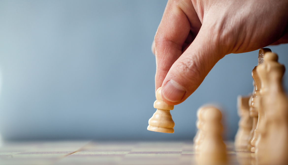 hand moving chess pawn on blue background