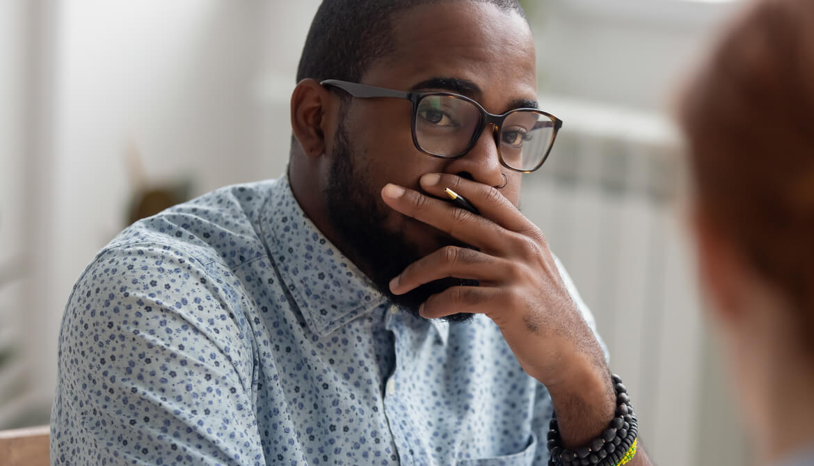 Unpleasantly surprised african-american businessman listening female caucasian coworker 