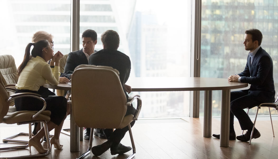 board room meeting with one executive separate from the rest