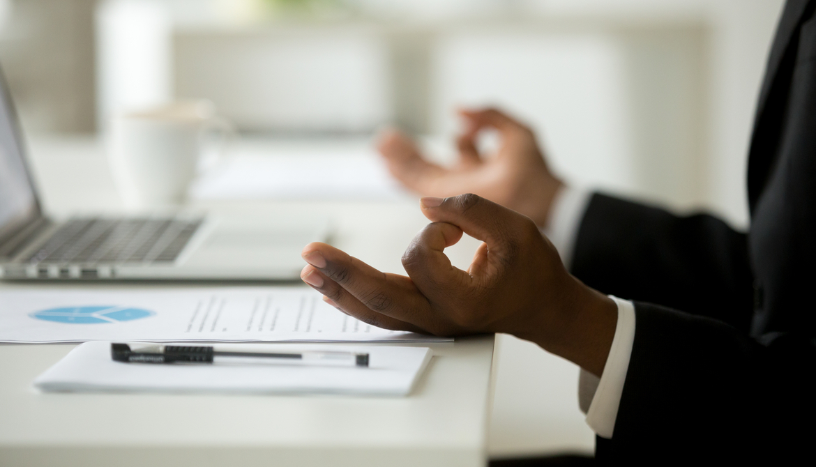 hands of a man meditating at his desk