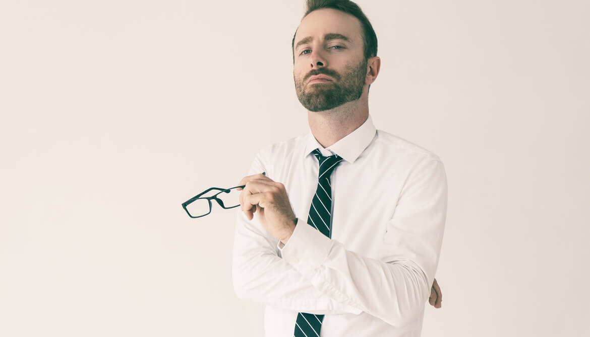 arrogant businessman holds glasses while looking haughty and condescending 