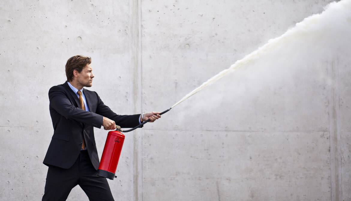 executive using fire extinguisher