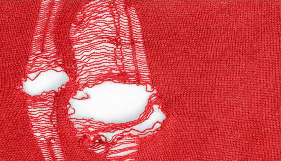 holes in red knitted fabric