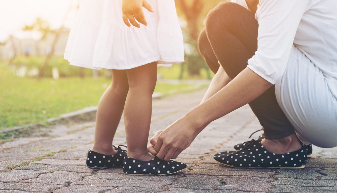 mom tying daughter's matching shoes