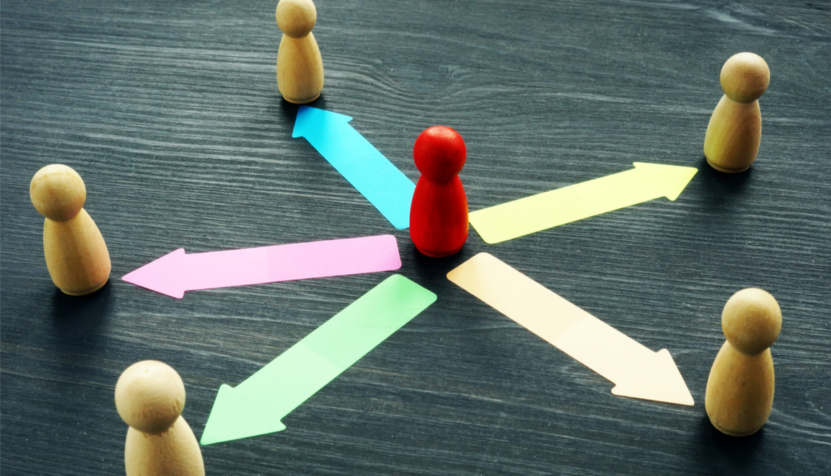 red wooden leader meeple figure with colorful arrows pointing outward to other meeples to represent delegation