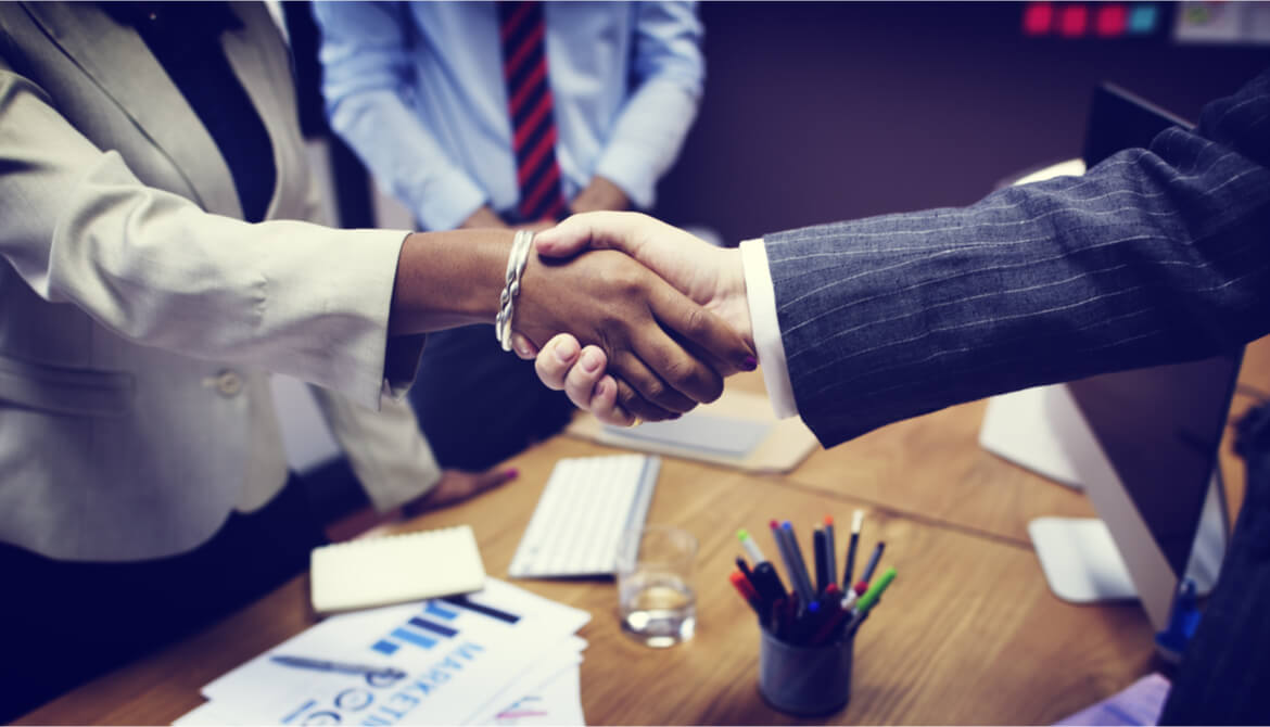 handshake of Black businesswoman and white businessman