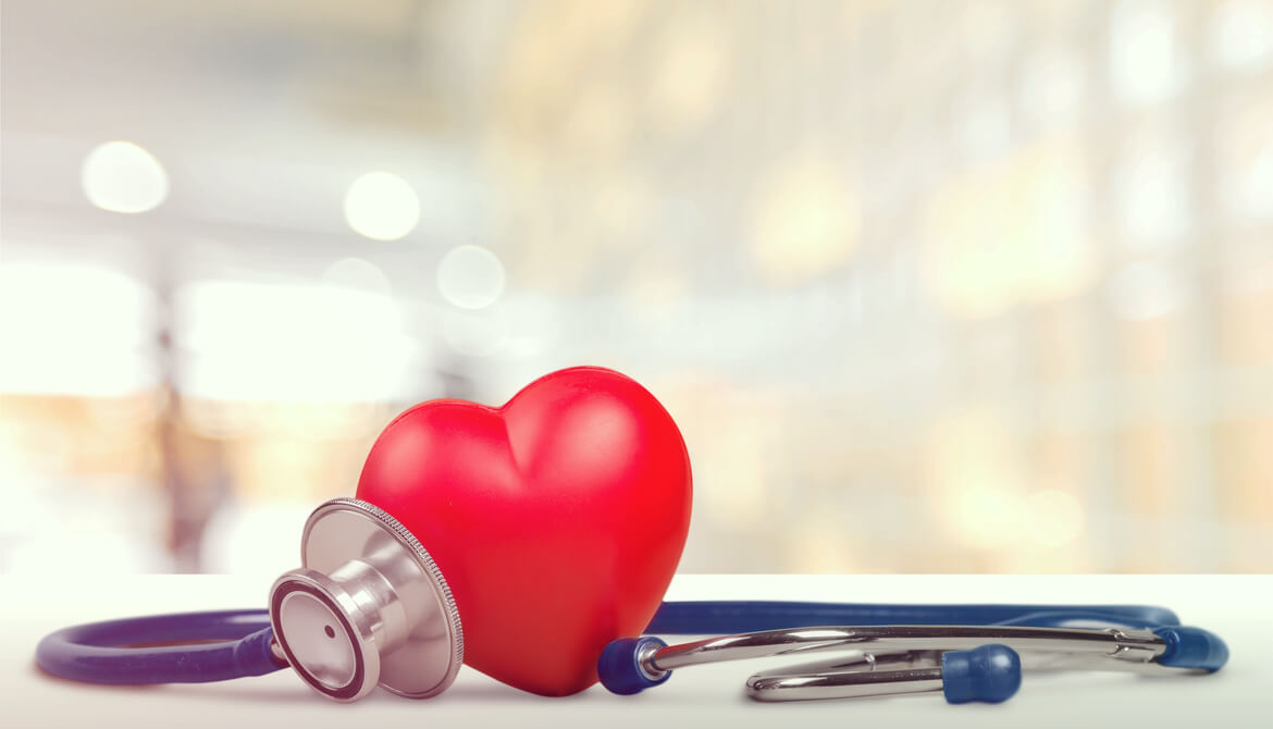 stethoscope arranged around a red heart on a table