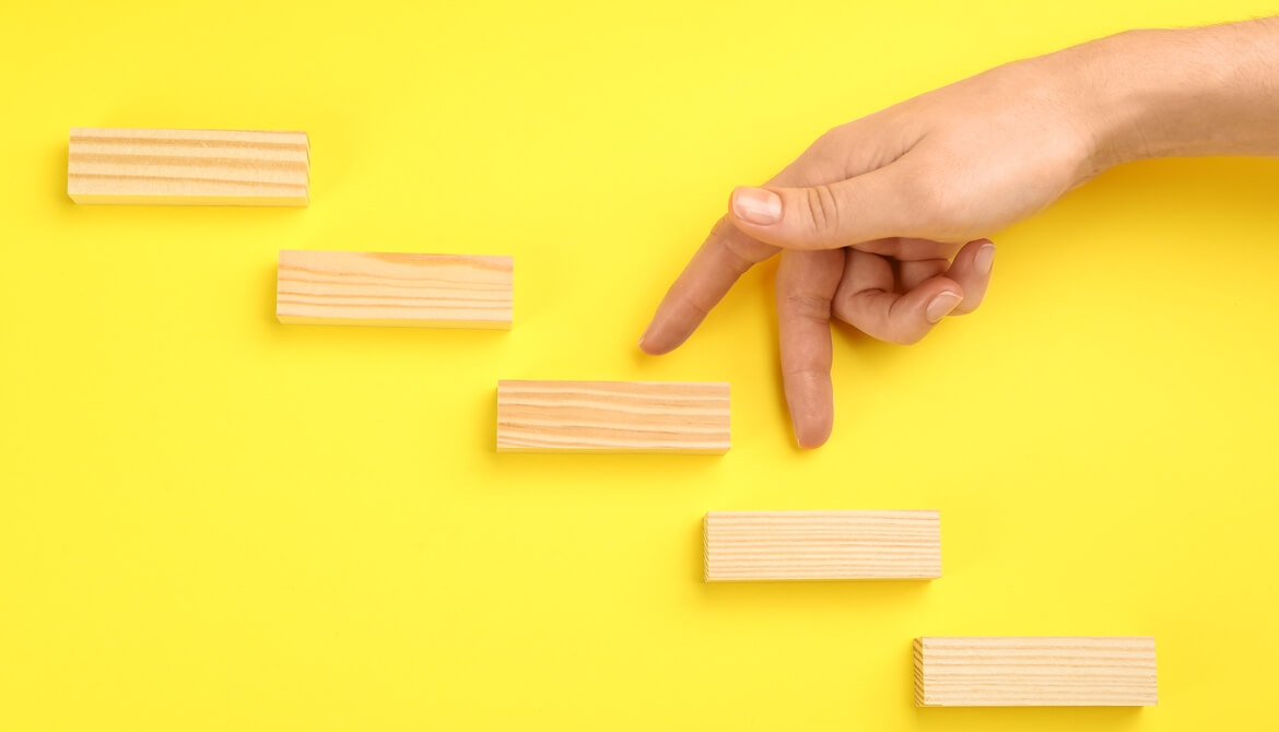 woman’s fingers walking up wooden block steps