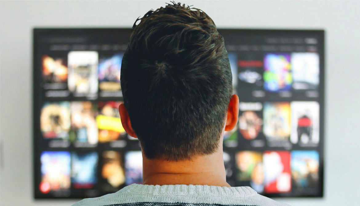 man watches his connected TV with many show choices