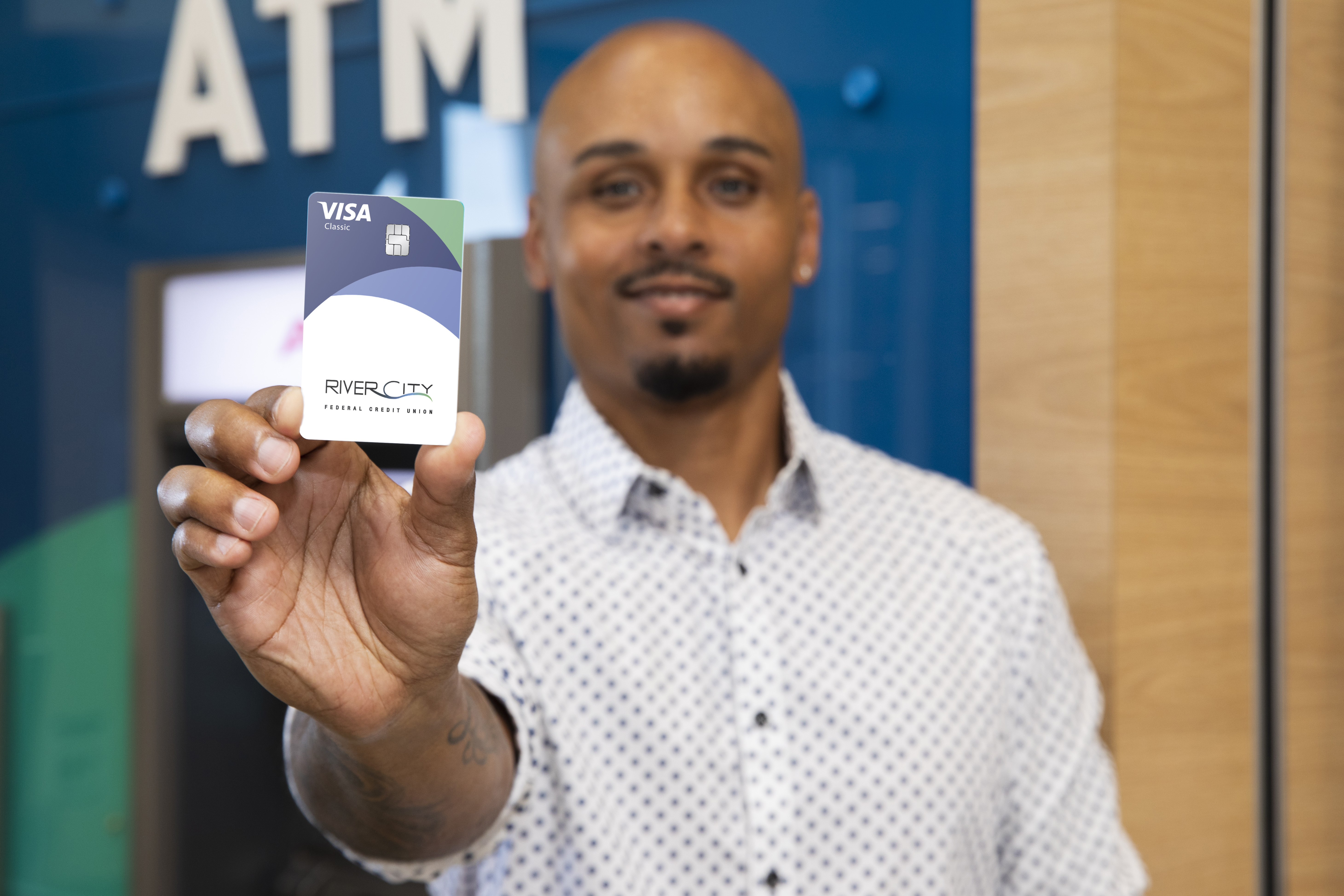 Josh Hatcher of Vericast displays River City FCU customized payments card in front of ATM