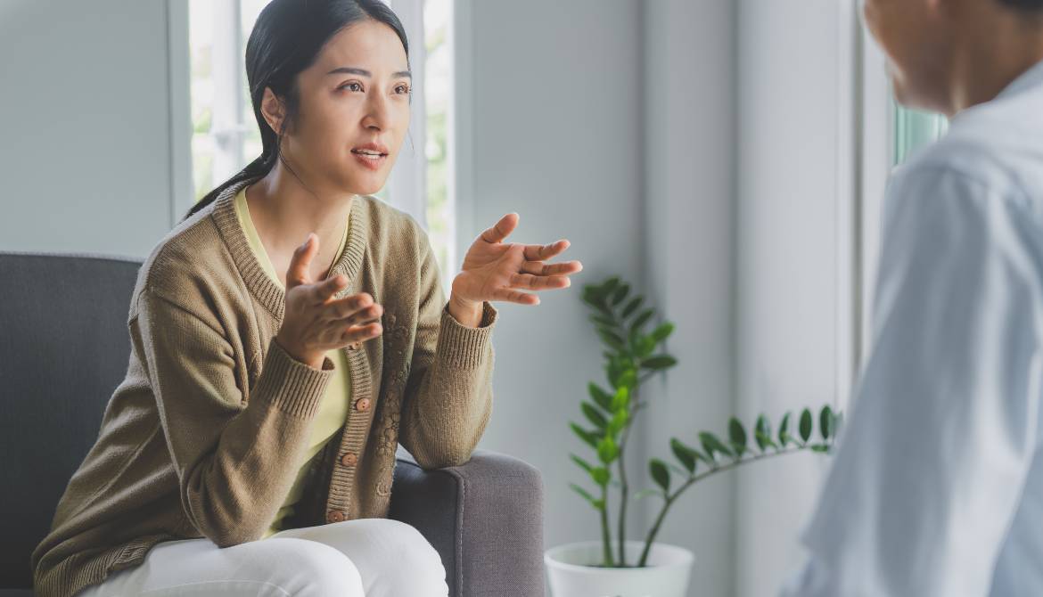 stressed female employee talks to well-being coach in office burnout clinic