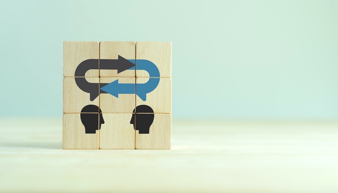 wooden blocks with silhouettes of faces communicating feedback to each other 