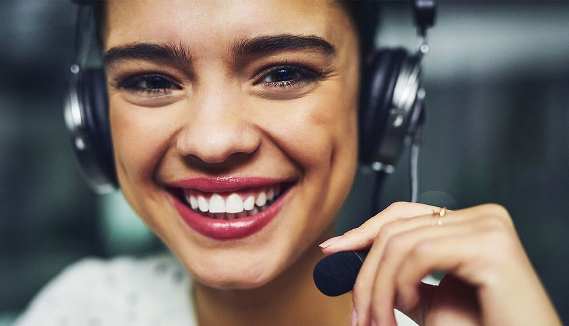 smiling young woman using headset in call center