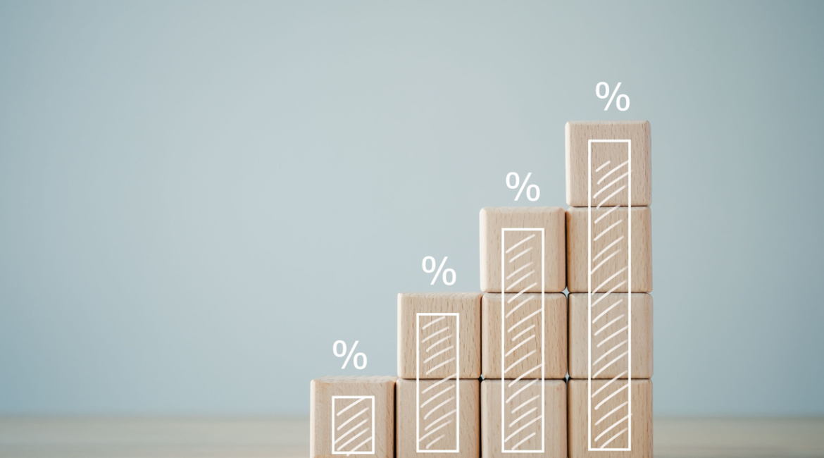 four wooden blocks with growth of bar chart percentage sign