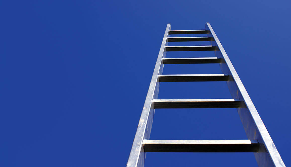 view from below of a ladder climbing high into blue sky