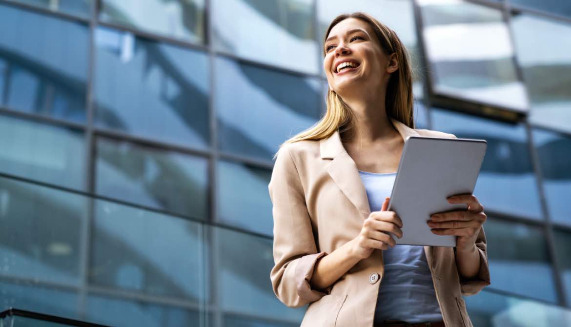 smiling business woman in front of building 