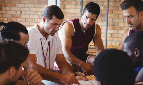 Coach explaining game plan to basketball players in the court