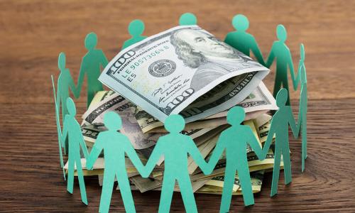 green paper dolls in a circle around cash