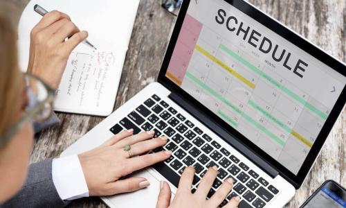 Business woman using laptop to set up calendar