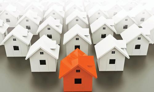 group of white houses in an arrow formation with orange house in front