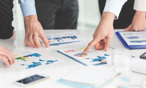 people studying charts and graphs on a table