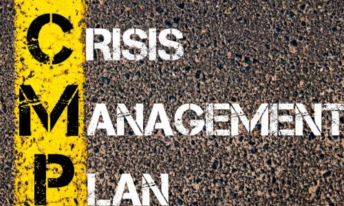 CRISIS MANAGEMENT PLAN painted on an asphalt road