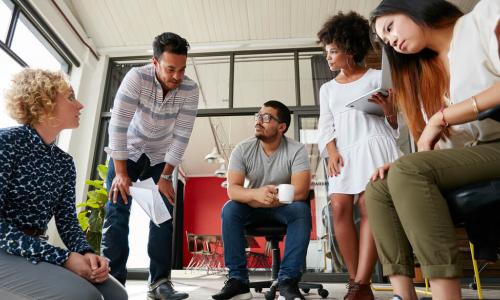 Group of young creative team going over some plans together