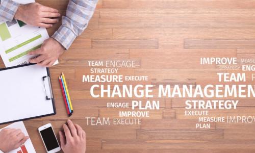 people working together with words about change management on wooden table