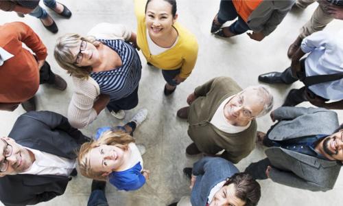 diverse group of happy people looking up at camera