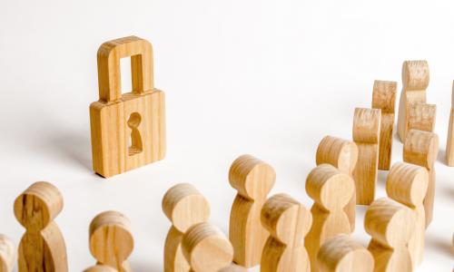 wooden padlock in front of group of wooden people