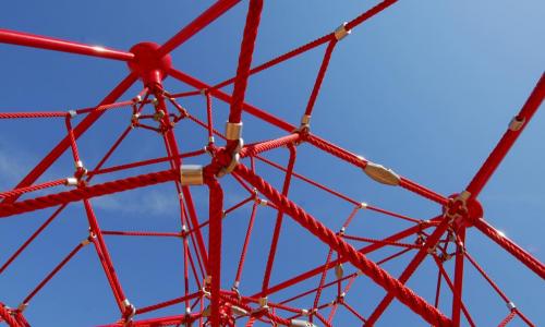 red jungle gym on blue sky