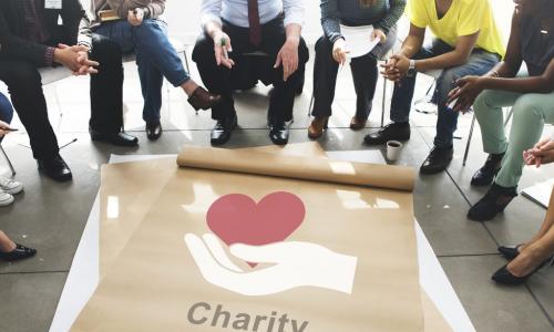 charity poster on floor with a work group