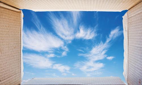 view of blue sky from inside open cardboard box