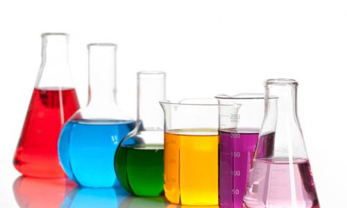 a variety of shaped lab beakers with different color liquid