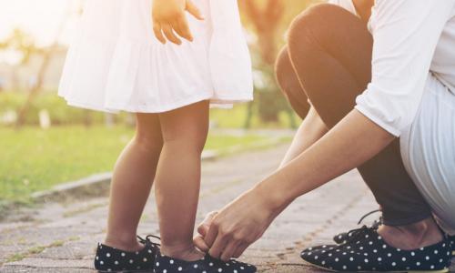 mom tying daughter's matching shoes