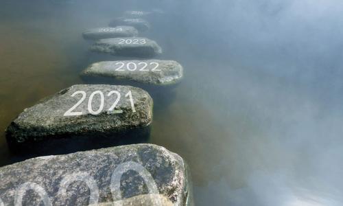 stepping stones labeled with 2021 and subsequent years crossing a misty river