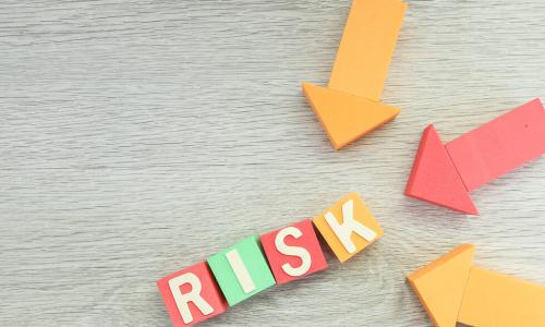 wooden blocks spelling out the word risk with wooden arrows pointing to them